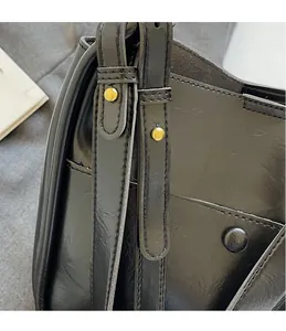 Macro shot of adjustable leather shoulder strap with polished gold-tone metal buckle