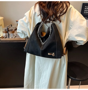 Retro black canvas tote bag with white contrast stitching shown on model back