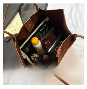Close-up of brown suede tote bag showing large capacity for laptop and cosmetics