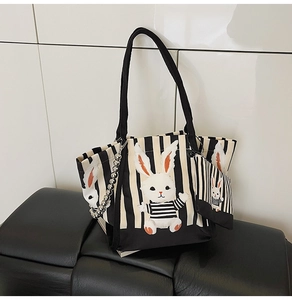 Dettaglio della borsa tote in tela a righe con patch a coniglio e portamonete coordinato