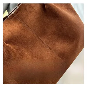 Macro shot of brown suede tote bag featuring high-quality double-line stitching and texture