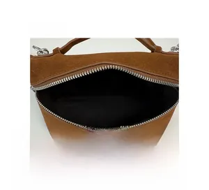 Detailansicht des braunen Wildleder-Handtaschen-Innenraums mit schwarzem Futter und Reißverschluss