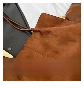 Detail of dark brown suede tote bag featuring fine stitching and matching leather pouch