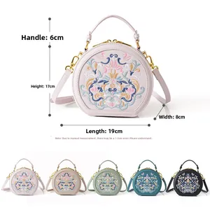 Detailed view of Chinese floral embroidery on the round cross-body bag with size labels