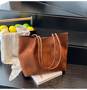 Detailed view of the dark brown suede tote bag featuring matte texture and slim shoulder straps