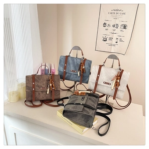 Détail de sacs à dos vintage en quatre couleurs avec sangles en cuir et breloque perle