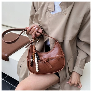 Detail of a brown Hobo bag with decorative knots and colorful wooden bead charms
