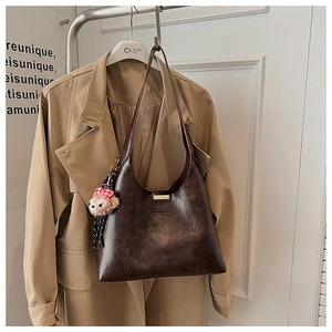 Brown vintage faux leather tote bag with a golden logo and a cute plush bear charm detail