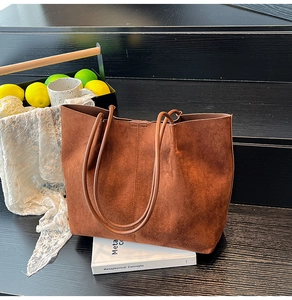 Detail of brown faux suede tote bag featuring vertical stitching and large capacity