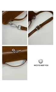 Detail der braunen Wildledertasche mit silbernen Metallhaken und verstellbarer Schnalle