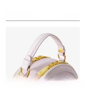 Close-up of lilac leather bag handle with gold ring connector and branded metal zipper