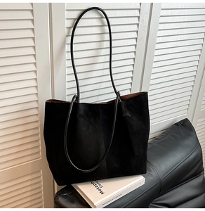 Detail of minimalist black suede tote bag showcasing soft texture and large capacity