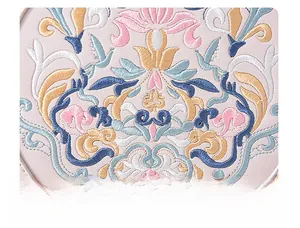 Detailed view of floral embroidery and pattern on a pink leather crossbody bag