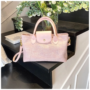 Borsa a mano in tweed rosa con patta in pelle e dettagli dorati su gradini neri eleganti