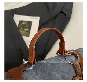 Détail d'un sac en denim bleu et cuir marron avec pendentif ethnique en perles de bois