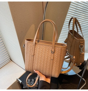 Detailed view of woven texture and silver hardware on khaki faux leather bucket bag