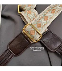 Adjustable woven shoulder strap detail with vintage patterns and gold-tone metal buckle