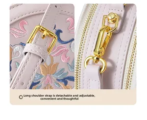 Detail view of adjustable metal buckle and detachable hook on floral embroidery bag