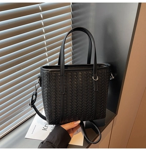 Detailed close-up of a black woven bucket bag showing premium PU leather texture