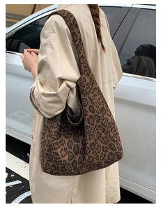 Street style shot of a large leopard print tote bag with wide shoulder strap details