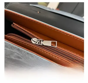Détail de la fermeture éclair argentée et du compartiment interne du sac à dos gris
