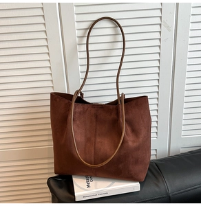 Detail view of large dark brown suede tote bag with minimalist vertical stitching decoration