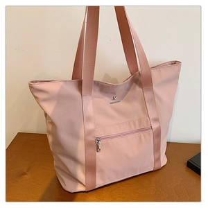 Détail du sac fourre-tout en tissu Oxford rose clair avec poche zippée et logo en métal