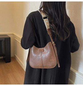 Detailed view of vintage brown bucket bag with ethnic jacquard woven shoulder strap
