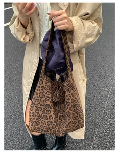 Outdoor street shot of a large leopard print tote bag paired with a casual trench coat
