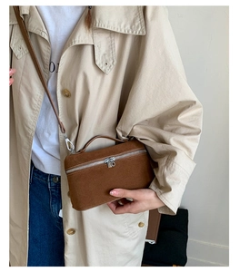Detailansicht der braunen Wildleder-Boxtasche mit Metall-Reißverschluss und Griff