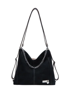 Retro black faux suede tote bag with silver chain and heart pendant on white background