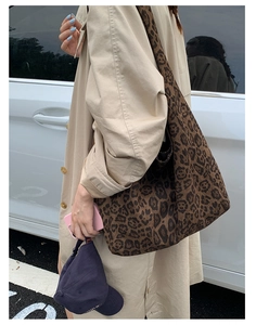 Chic leopard print hobo tote bag worn over the shoulder with a neutral trench coat