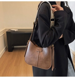 Vue détaillée du sac porté épaule en cuir marron vintage avec large bandoulière brodée