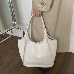 Detail of cream woven tote bag showing Intrecciato leather texture and large capacity