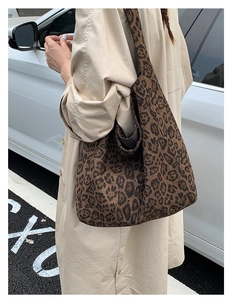 Detailed view of leopard print tote bag on shoulder with autumn trench coat