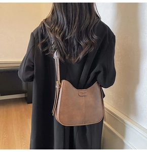 Vue détaillée d'un sac besace rétro marron avec finition mate et surpiqûres verticales