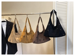 Détails de motifs floraux découpés au laser sur des sacs cabas en daim de diverses couleurs