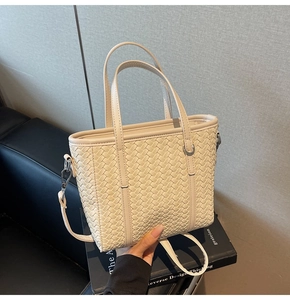 Close-up of off-white woven PU leather mini tote bag with adjustable strap and silver rings