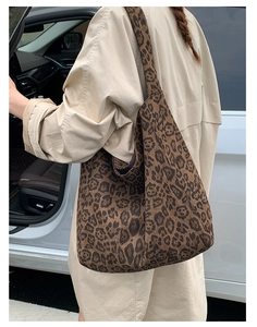 Outdoor street shot of large leopard print tote bag worn with a beige trench coat