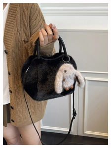 Detail der schwarzen Kunstfell-Handtasche mit süßem Kaninchen-Anhänger und Ledergriff