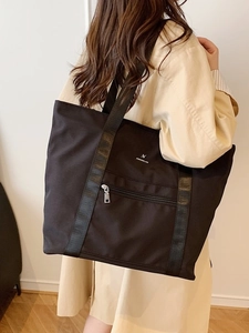 Grand sac fourre-tout noir en tissu Oxford porté par un mannequin avec larges bretelles