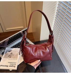 Detail of burgundy PU leather shoulder bag with star-shaped silver zipper puller