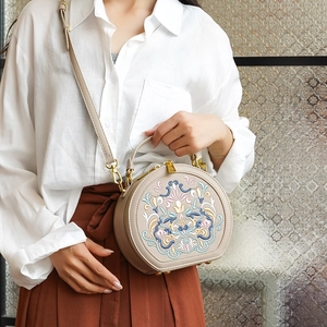Detailed embroidery of vintage floral pattern on beige crossbody bag with matte leather