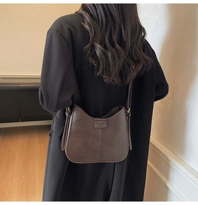 Sac Hobo vintage en cuir PU marron porté par un modèle pour un look quotidien