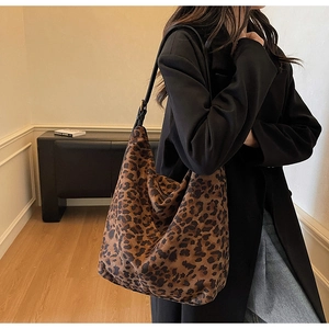 Detail of a large leopard print hobo bag with sleek black leather shoulder straps