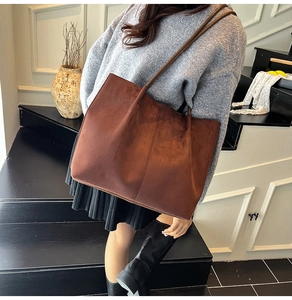 Detail of caramel brown suede tote bag featuring vintage texture and vertical stitching