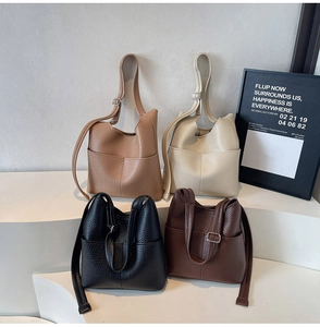 Detailed view of four colors of lychee grain bucket bags on white tiered stairs display