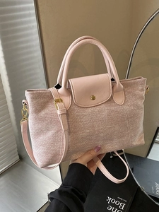 Borsa tote in denim rosa con manici in pelle e finiture dorate in un ambiente di stile
