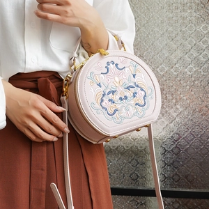 Detail of elegant pink embroidered crossbody bag featuring vintage floral patterns