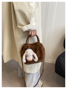 Detailansicht der braunen Plüschhandtasche mit Kunstfell und weißem Hasenanhänger
